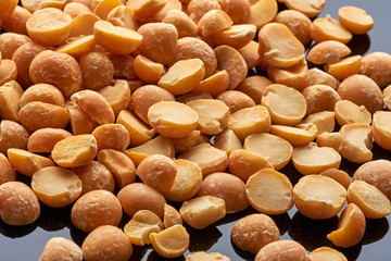 a lot of pea groats poured onto a black reflective surface, macro photography,