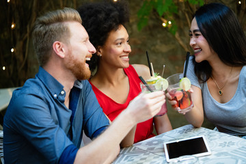 Diverse group of happy friends having fun, talking in cafe outdoor at summer