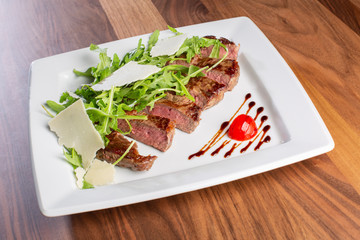 details of tasty beef tagliata with arugula and parmesan