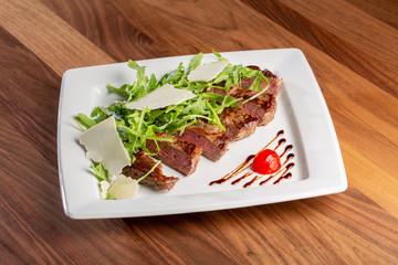 details of tasty beef tagliata with arugula and parmesan