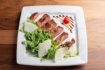 details of tasty beef tagliata with arugula and parmesan