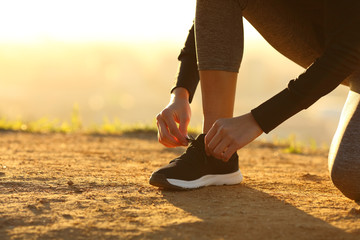Closeup of runner woman hands tying shoelaces of shoes
