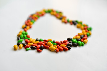 
heart made of small multi-colored sweets