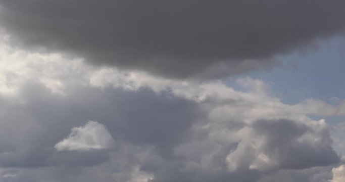 Time lapse clip of several fluffy curly rolling cloud layers in windy weather before the storm with sun rays