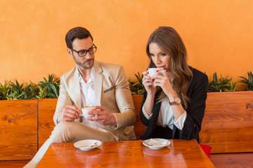 Attractive business man and business woman drinking coffee