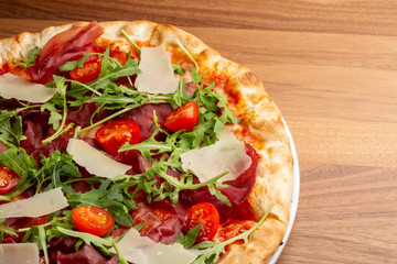 details of tasty italian ham and arugula pizza