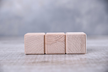 One blank wooden cube with space for your word, letter, symbol on the table. Place for text, free copy space