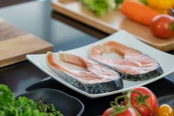 Fototapeta na wymiar Closeup raw fresh salmon fish steaks with fresh vegetable.