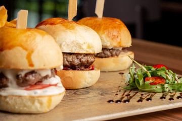 close up of fresh tasty mini burgers and potatoes