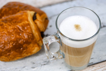 cappuccino et pain au chocolat sur une table