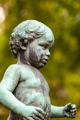 Fototapeta na wymiar Statue of boy in park in Baden-Baden