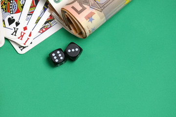 playing cards ,  game dice, money on the green poker table.  Gambling. 