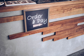 order and pay wooden chalkboard tag on counter bar in cafe or retail shop