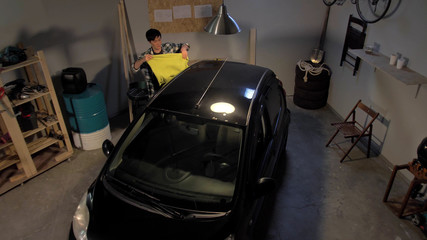 Fototapeta na wymiar Guy washes a car in the garage