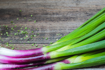 details of spring onions on a wooden table with copy space