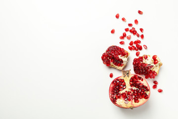 Pomegranate and seeds on white background, space for text