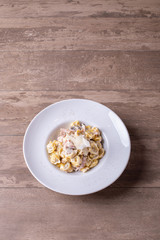 details of fresh, hot tortellini carbonara, with parmesan