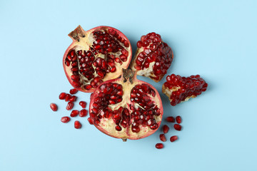 Pomegranate and seeds on blue background. Concept of juicy fruit