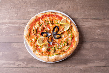 close up of sea food pizza on wooden background