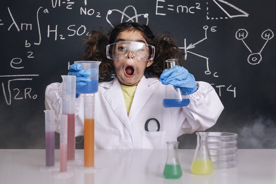 surprised scientist child in lab coat with flasks