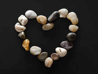 Heart made of little stones on dark background