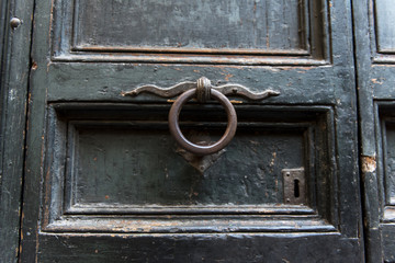 An old metal knocker on a old wooden door