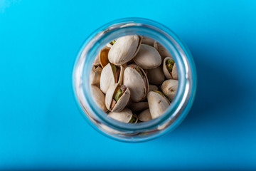 contenedores de cristal con pistachos sobre un fondo azul