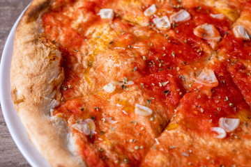 details of tomato garlic pizza on a wooden background