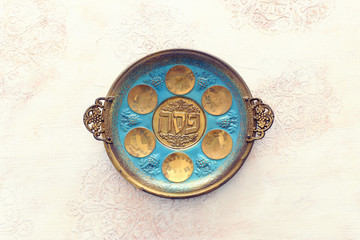 Pesah celebration concept (jewish Passover holiday). Traditional pesah plate text in hebrew: Passover, horseradish, celery, egg, bone, maror, sweet dates jam