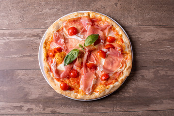 close up of fresh baked ham, cheese and tomato cherry pizza