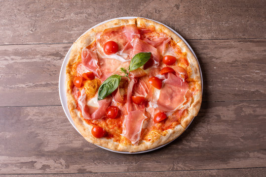 close up of fresh baked ham, cheese and tomato cherry pizza