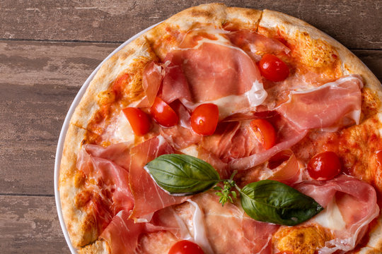 close up of fresh baked ham, cheese and tomato cherry pizza