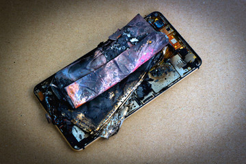 Smartphone battery close up. Explode on brown paper background.