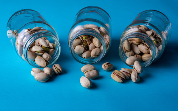 pistachos en envases de cristal sobre un fondo azul