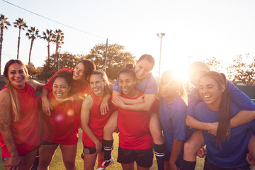 Portrait Of Womens Football Team Relaxing After Training For Soccer Match On Outdoor Pitch
