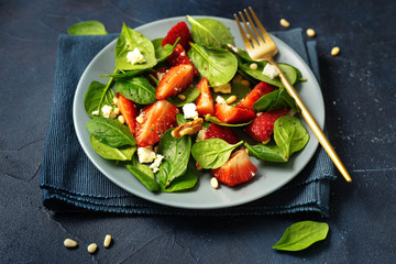 Close up of vegetarian slalad with strawberries, feta cheese, spinach and nuts