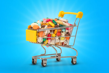 Mini shopping cart with pills and tablets isolated on color background