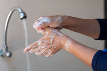 Fototapeta premium Muslim women wash hand with soap alcohol gel for sanitizer in kitchen sink concept for prevent Hygiene health care. Quarantine Islam people spread of germs and microbe bacteria outbreak coronavirus 19