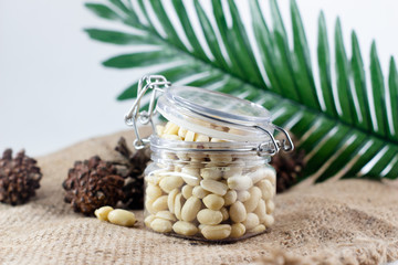 jar of peanuts  with leaves on burlap