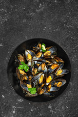 Top view of delicious freshly cooked mussels on black background
