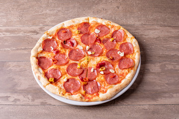 fresh tasty salami pizza on a wooden background