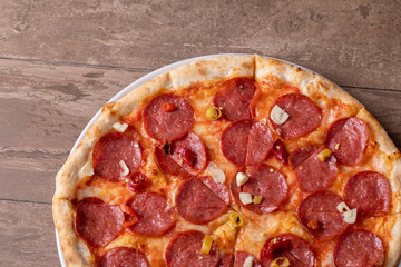 fresh tasty salami pizza on a wooden background