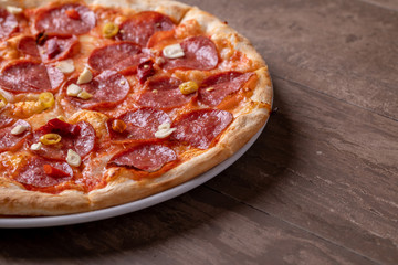 fresh tasty salami pizza on a wooden background
