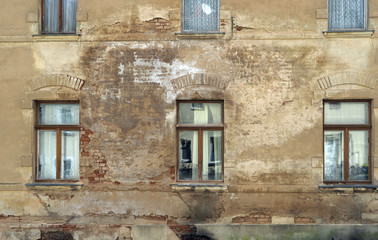 Fototapeta na wymiar Historische beschädigte ,feuchte Hausfassade mit alten Holzfenstern