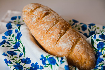 Freshly baked homemade bread on napkin with blue flowers. Close-up.
