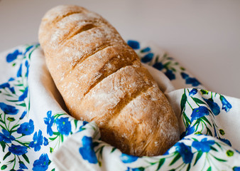 Fresh baked homemade bread on napkin with blue flowers. Close-up.