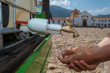 Sink in the main square of Villa de Leyva Boyacá Colombia is used by a man with the aim of...