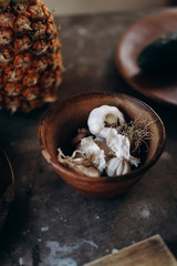 The heads of garlic lie in a ceramic plate on a concrete table