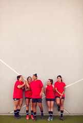 Graphic Shot Of Womens Football Team Leaning Against Wall Whilst Training For Soccer Match