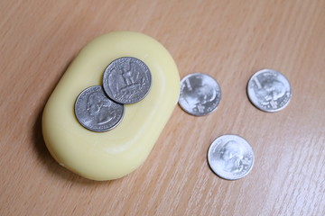 several metal coins of two euros lie on a bar of soap. metal coins of one quarter dollar and liberty lie. concept coronavirus, epidemic, pandemic, covid19.